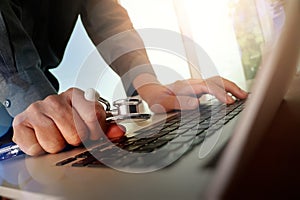 Doctor working at workspace with laptop computer in medical work