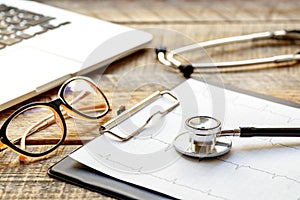 Doctor workplace with a stethoscope at wooden table