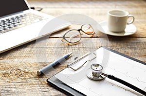 Doctor workplace with a stethoscope at wooden table