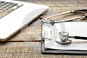 Doctor workplace with a stethoscope at wooden table