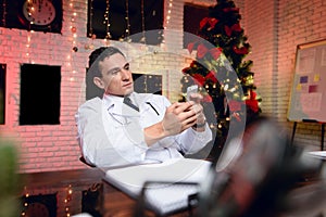 The doctor works on New Year`s Eve. He is talking on the phone.