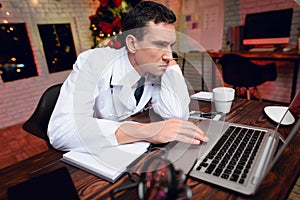 The doctor works on New Year`s Eve. He is very tired but continues to work.