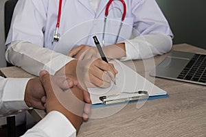 Doctor write on medical examination or prescription note at hosp