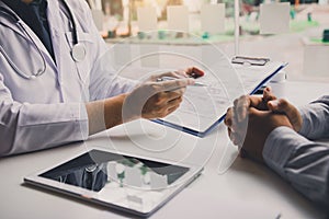 Doctor is writing the appointment letter to the patient at the clinic photo