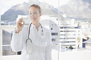 Doctor writing on a clear board