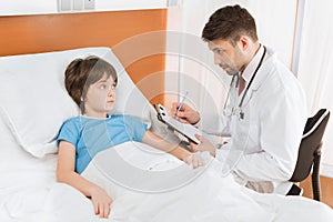 Doctor writing down child patient`s symptoms