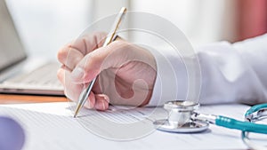 Doctor writing on medical health care record, patients discharge, or prescription form paperwork in hospital clinic office