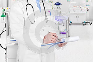 Doctor writing a medical prescription in delivery room