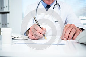 Doctor writing on paper at clinic