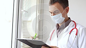 Doctor writing patient notes on a medical examination or prescription.