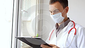 Doctor writing patient notes on a medical examination or prescription.