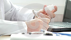 Doctor writing a prescription at desk i