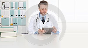 Doctor writing prescription at desk in medical office with digital tablet, copy space and web banner