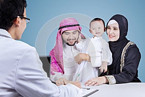 Doctor writing a prescription to his patient