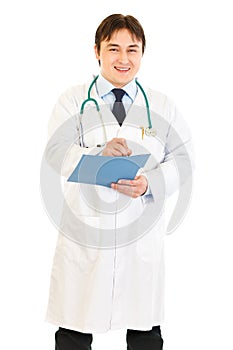 Doctor writing report in medical chart of patient