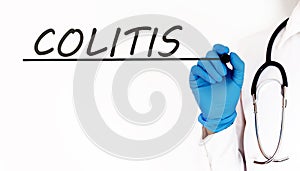 Doctor writing word COLITIS Medical concept on white background