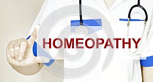 Doctor writing word HOMEOPATHY with hands, Medical concept