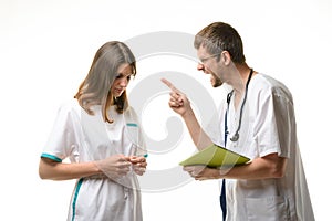 The doctor yells at the intern for an error in the patient`s record photo
