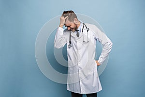 Doctor young man, medical professional terrified and nervous expressing anxiety and panic gesture, isolated over blue