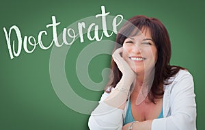 Doctorate Written On Green Chalkboard Behind Smiling Woman