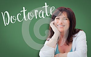 Doctorate Written On Green Chalkboard Behind Smiling Woman photo