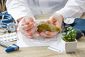 At doctors appointment physician shows to patient shape of pancreas gland with focus on hand with organ. Scene explaining patient