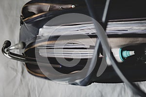 A doctors bag at a clinic - showing stethoscope, otoscope and thermometer.