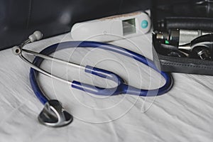 A doctors bag at a clinic - showing stethoscope, otoscope and thermometer.