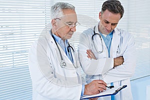 Doctors discussing over clipboard