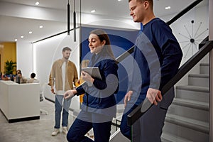 Doctors discussing patient medical reports together at clinic hallway stairs