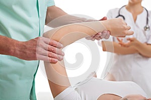 Doctors examining injured arm photo