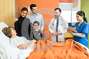 Doctors Explaining Family With Senior Patient At Hospital