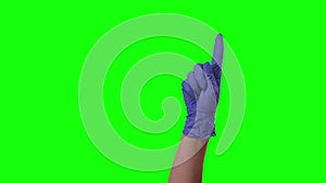 Doctors female hand in blue glove is making symbolic gestures pointing something. Green screen. Close up