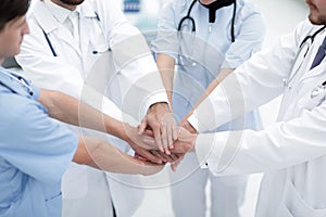 Doctors holding hands together at hospital