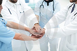 Doctors holding hands together at hospital