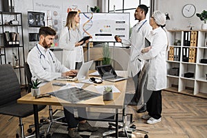 Doctors with laptop having sesion in lab boardroom photo