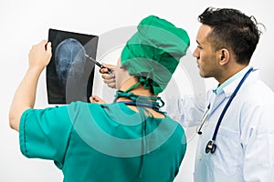 Doctors looking at x-ray film of patient `s head
