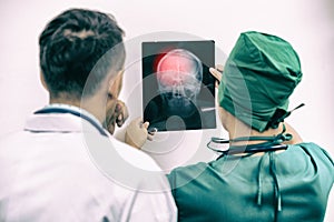 Doctors looking at x-ray film of patient `s head