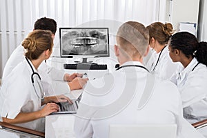 Doctors Looking At Teeth X-ray On Computer