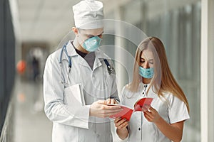 Doctors in masks are discussing the problem in a hall photo