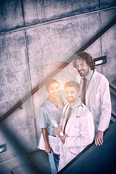 Doctors and nurse holding medical reports standing on stairs