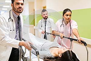 Doctors And Nurse Pushing Patient On Gurney In Hospital