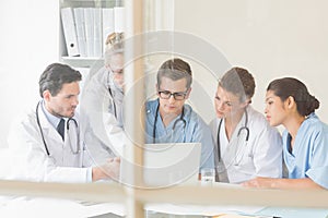 Doctors and nurses discussing over laptop