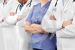 Doctors and nurses in healthcare team with arms crossed in a row in hospital