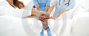 Doctors and nurses in a medical team stacking hands