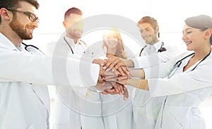 Doctors and nurses in a medical team stacking hands