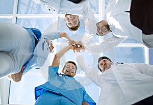 Doctors and nurses in a medical team stacking hands