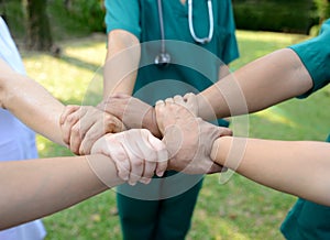 Doctors and nurses in a medical team stacking hands outdoor on t