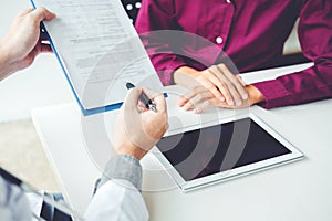 Doctors and patients sit and talk. At the table near the window