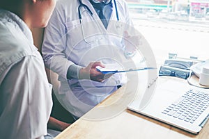 Doctors and patients sit and talk. At the table near the window photo